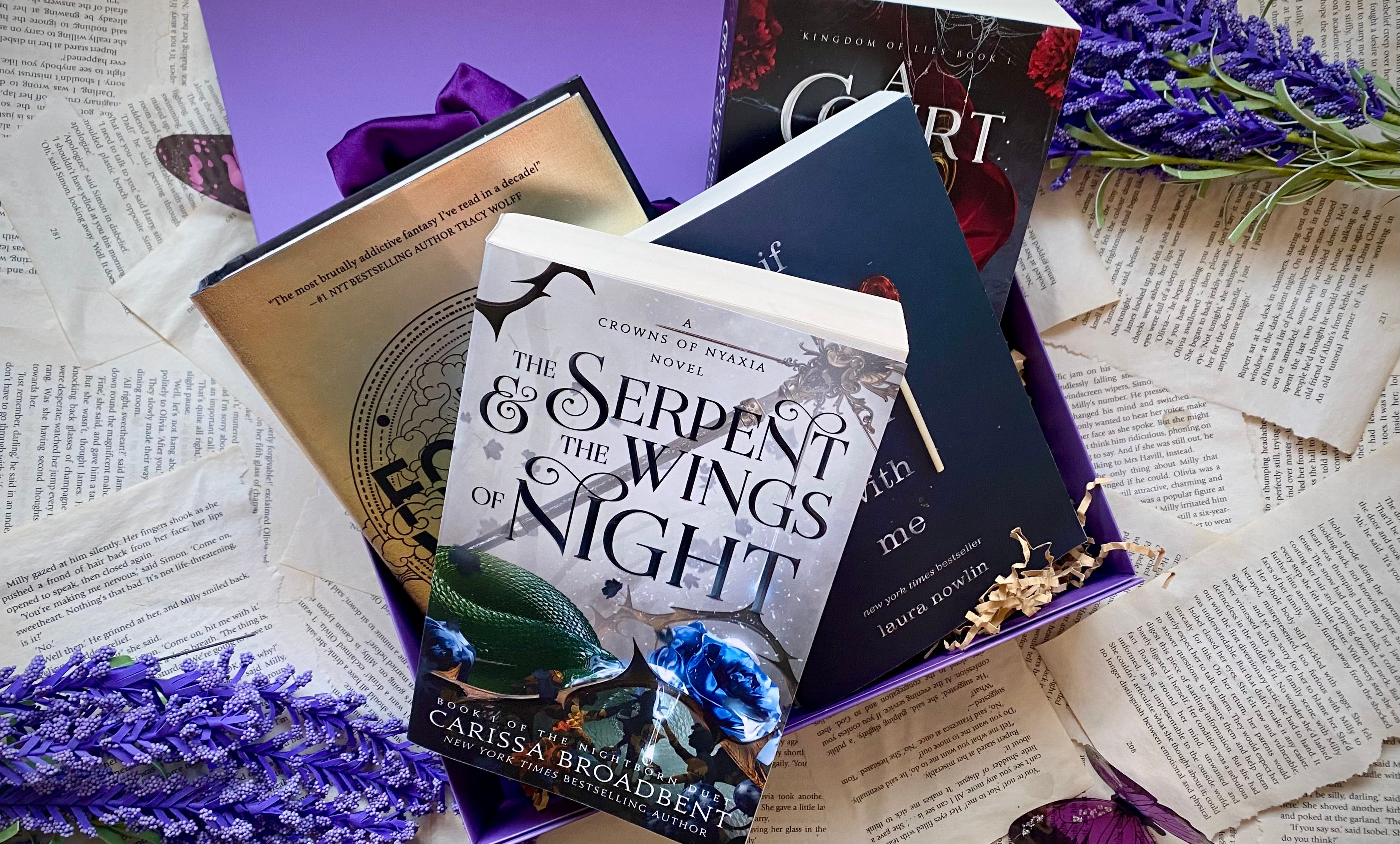 Purple monthly book subscription box featuring four fantasy romance novels, including ‘The Serpent and the Wings of Night’ by Carissa Broadbent, ‘Fourth Wing’ by Rebecca Yarros, and ‘A Court This Cruel and Lovely’ by Stacia Stark – perfect for fans of romantic fantasy book series